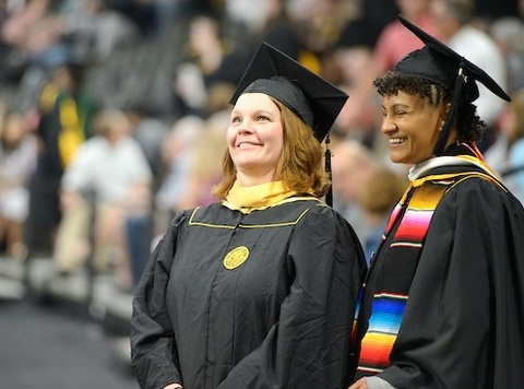 Two UI students at a master's commencement ceremony