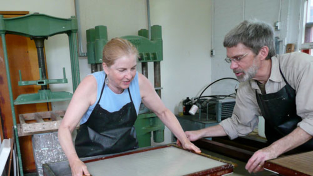 Tim Barrett assists a student in the art of papermaking.