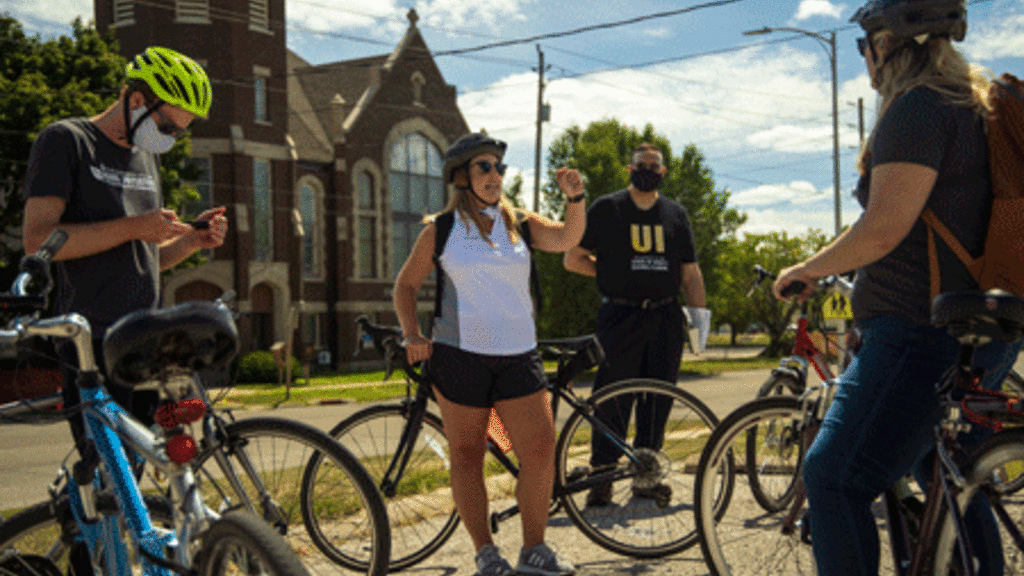 Adrienne Miller, planner and economic development specialist for the City of Waterloo, leads the University of Iowa visitors on the bike tour through the Church Row neighborhood.